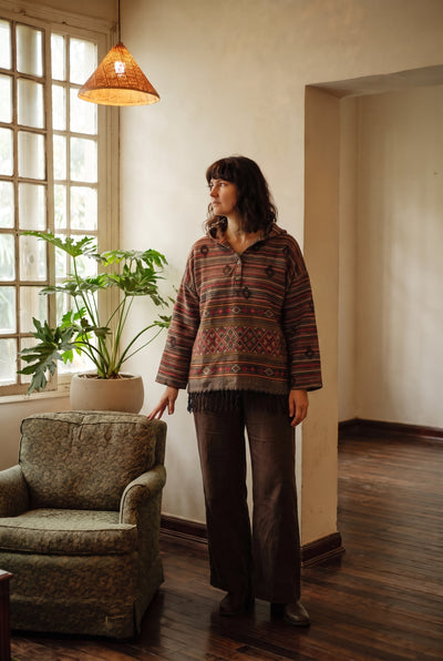 Model wearing the Emberfall Hooded Pullover in rust and charcoal stripe, full length, hood down.