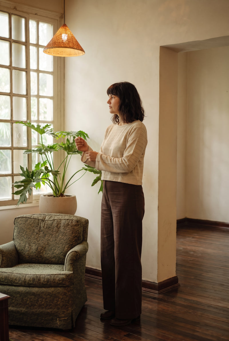 Model wearing the Lichen Knit Top in Oat — undyed marl knit with bell cuffs.