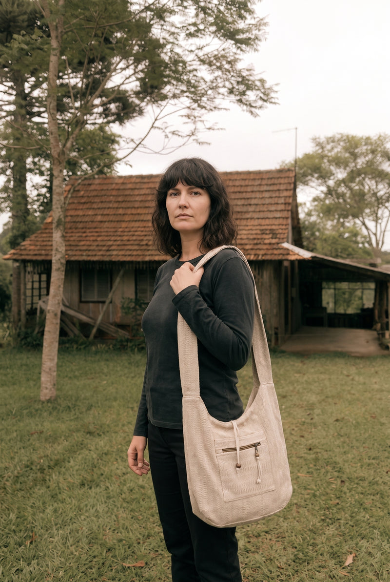 The Nomad Hemp Sling Bag in Natural — deep rounded body resting at the hip on a wide shoulder strap.
