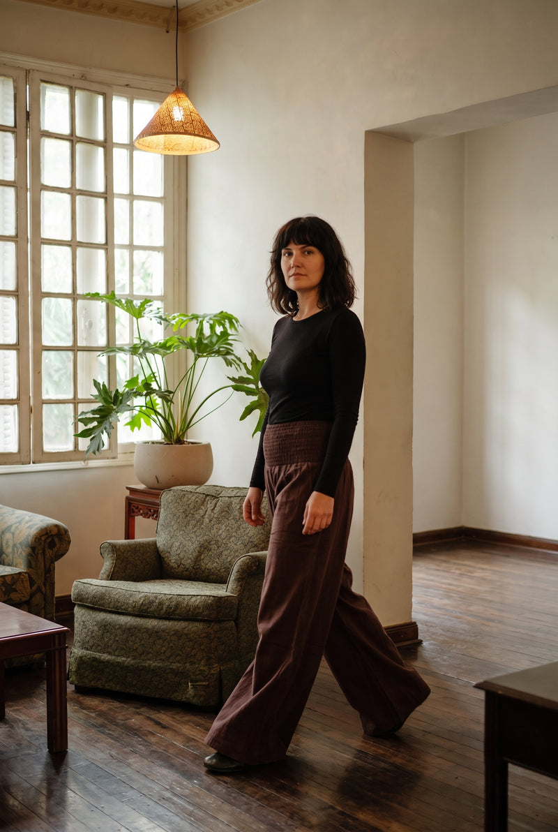 The Peatfield Wide-Leg Pants in Cocoa mid-step, floor-length drape.