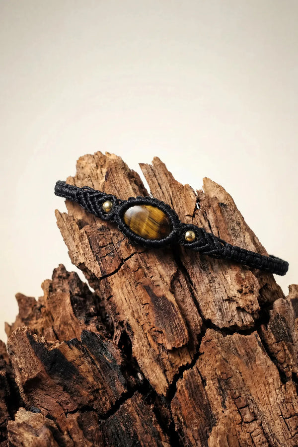 Woven Tigers Eye Bracelet with black cord, golden-brown striped oval stone, and small gold beads.