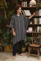 Reed wearing the Handmade Black Nepalese Poncho, plant room