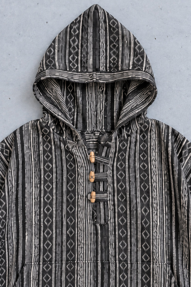 Close-up of the Handmade Black Nepalese Poncho hood, toggles and woven stripe
