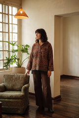 The Emberfall Hooded Pullover, three-quarter view showing the woven stripe bands and fringe hem.