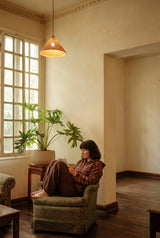 Outfit: Emberfall Hooded Pullover with Peatfield Wide-Leg Pants in Cocoa, curled into the armchair with a book.
