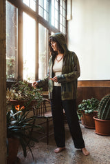 Ana wearing the Green Horizon Patchwork Jacket, plant room