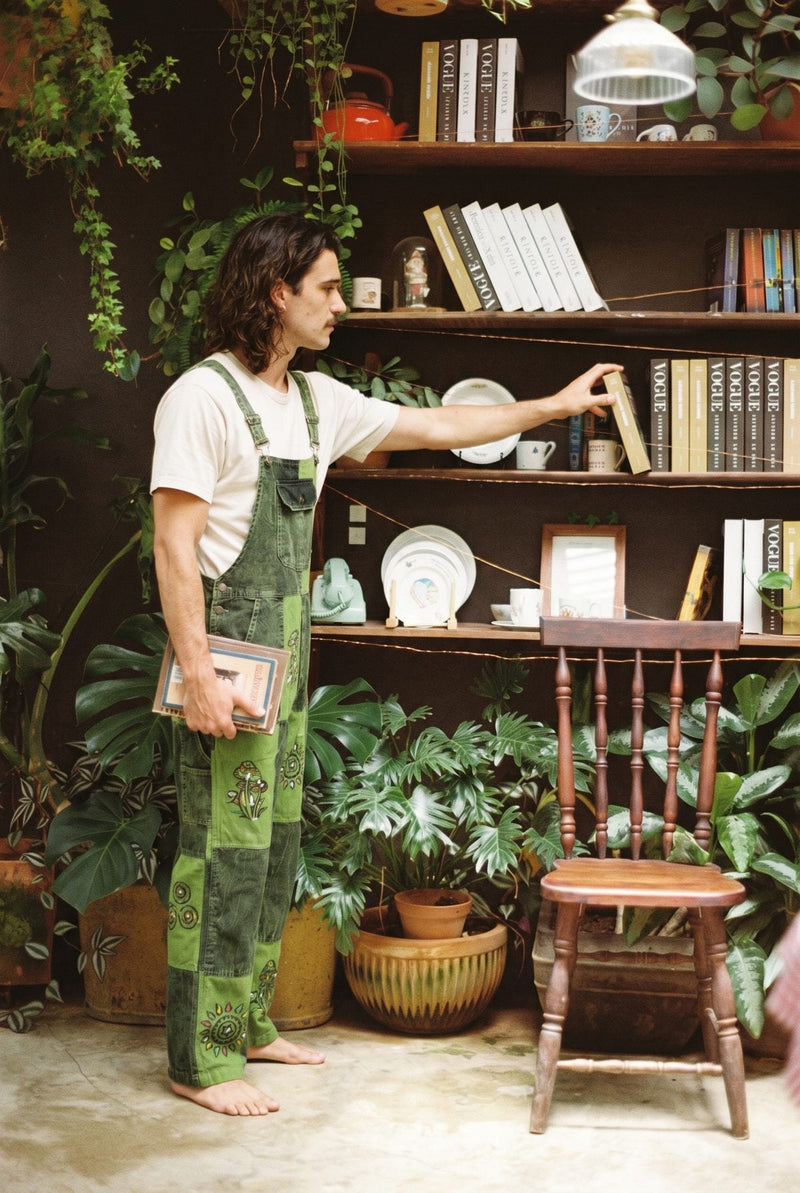Sungrove Overalls in side profile, stonewash lime and forest-green patchwork with the bib and buckle in view.