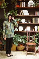Green Horizon Patchwork Jacket zipped with the hood up, green gheri stripe and black block prints.