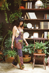 Duskwood Overalls in profile mid-stride, side seam, button placket and back-strap detail in view.