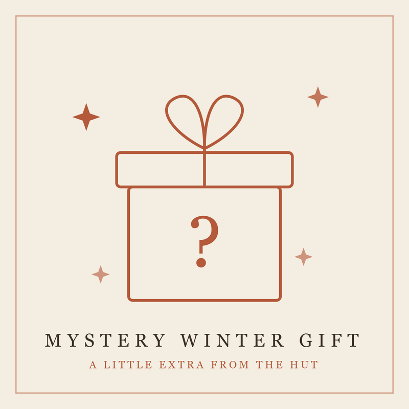 Rust-colored outlined gift box with heart-shaped bow and question mark, surrounded by decorative stars on cream background.