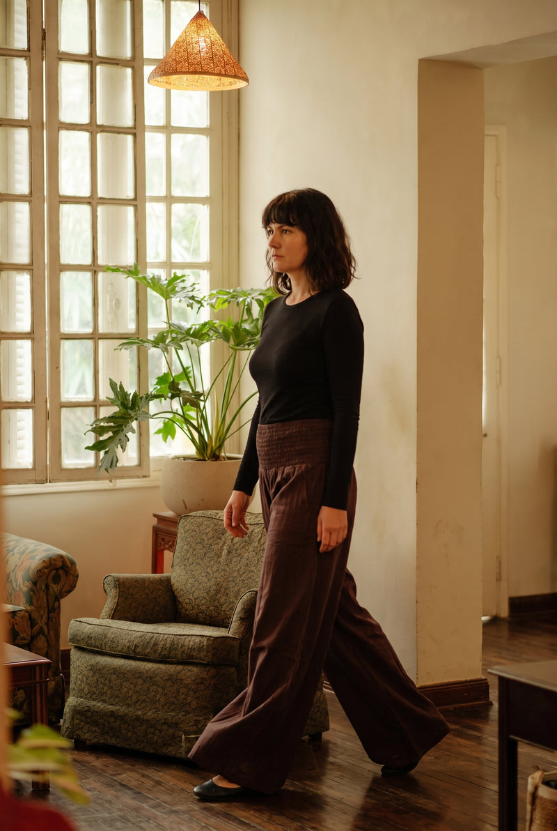 Model walking in the Peatfield Wide-Leg Pants in Cocoa — full palazzo flare in motion.