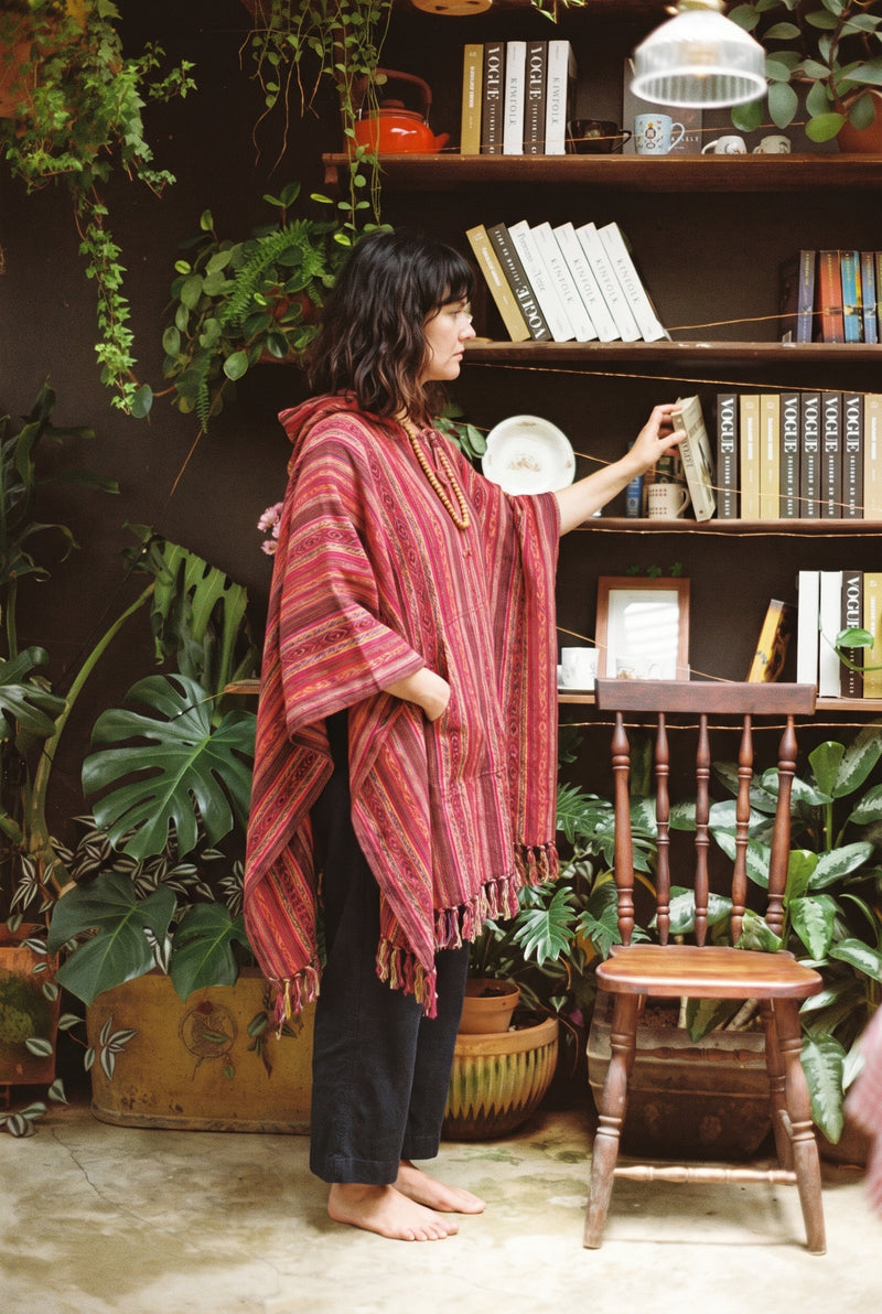 Ana wearing the Rosewood Gheri Poncho, plant room