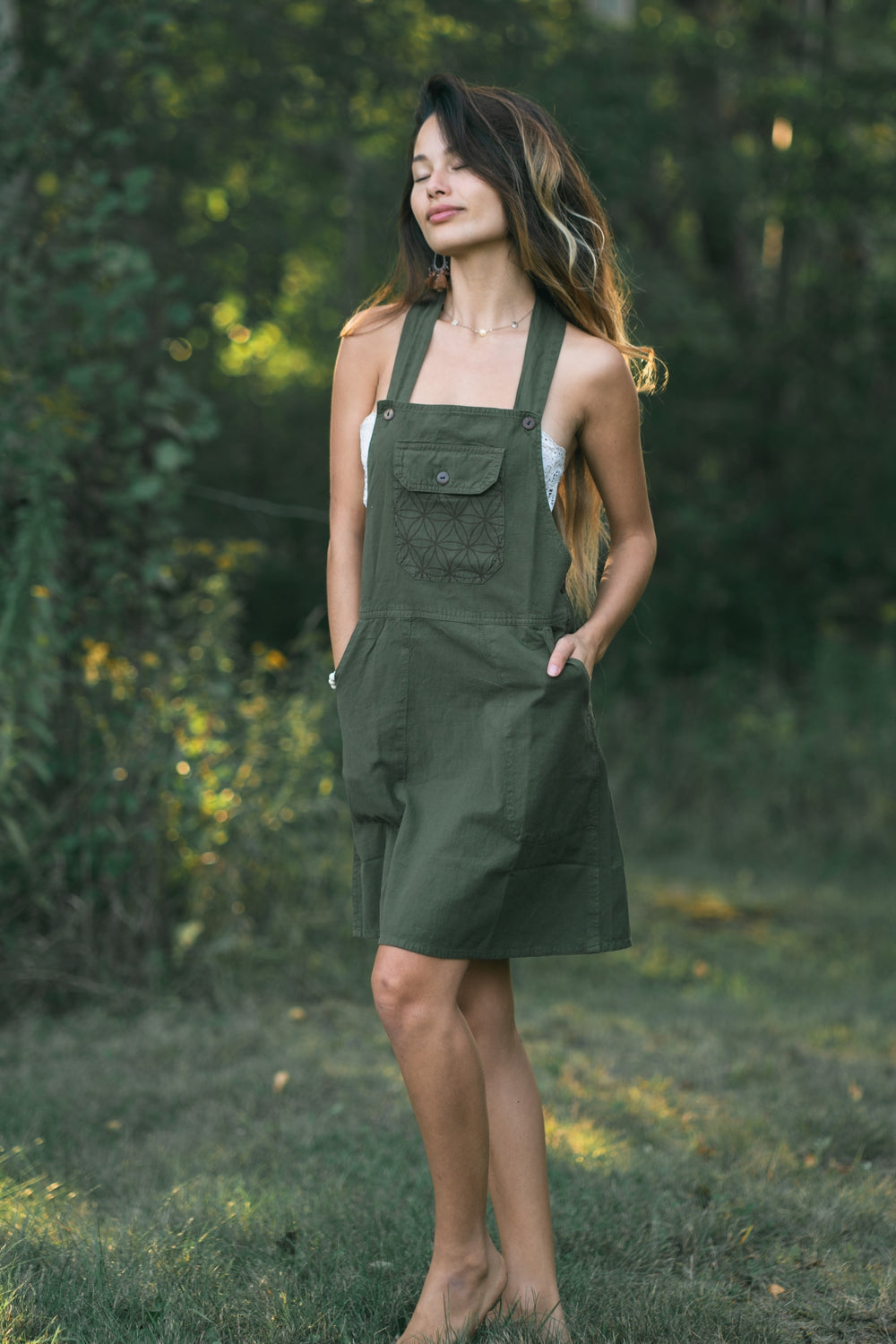 Olive green Rainforest dress with geometric-patterned front pocket, halter straps, snap buttons, knee length.