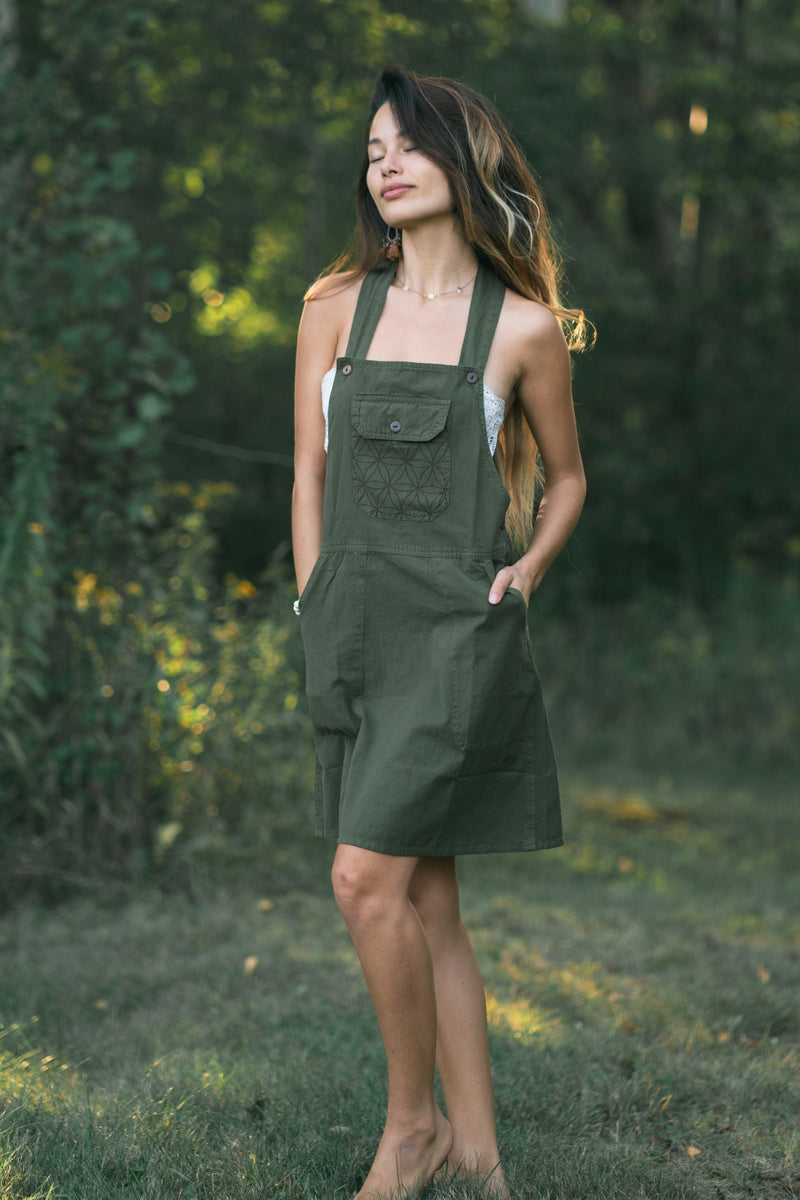Olive green Rainforest dress with geometric-patterned front pocket, halter straps, snap buttons, knee length.