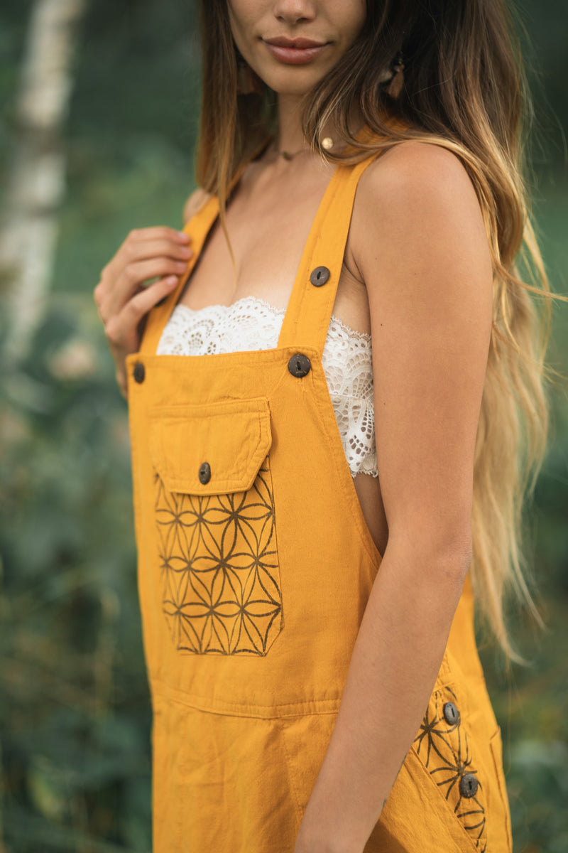 Mustard yellow Sunflower Dress with geometric flower patterns, black buttons, and white lace trim.
