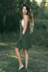 Sage green sleeveless A-line dress with deep side pockets and knee-length cut.
