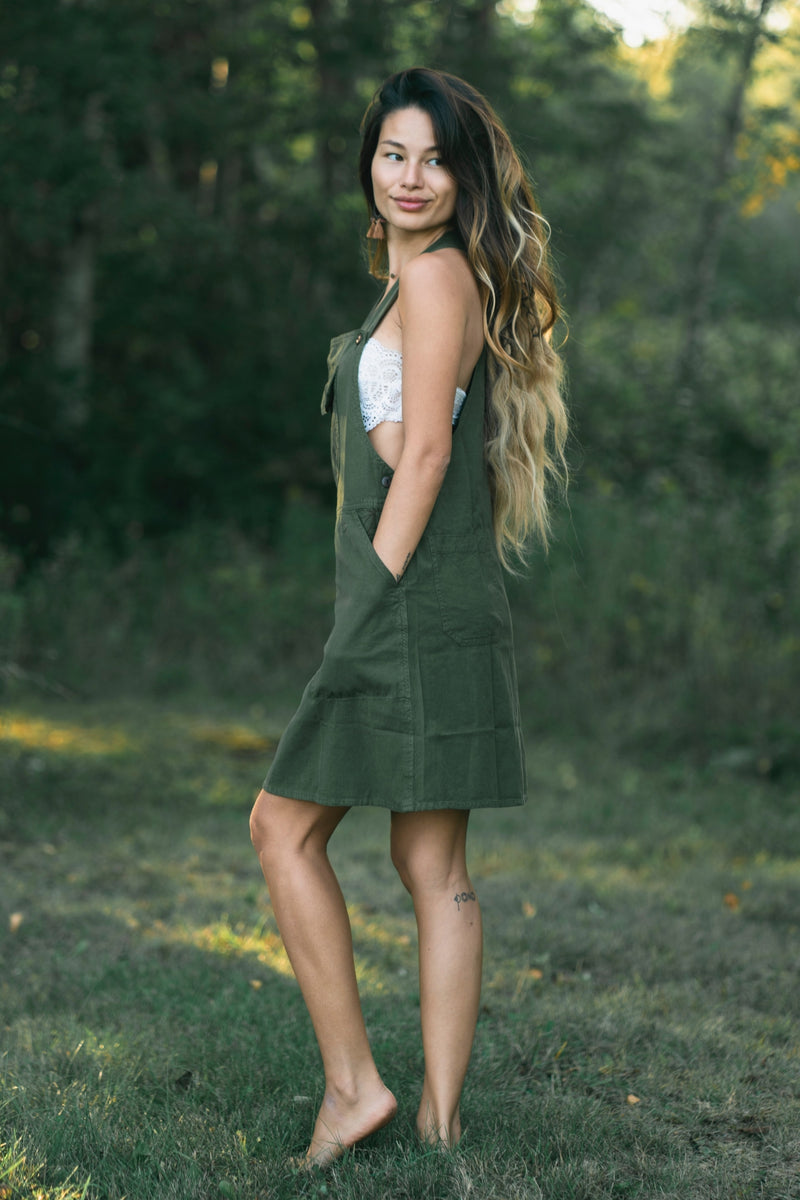 Sage green sleeveless A-line dress with deep side pockets and knee-length cut.
